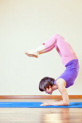 Asian woman doing exercise of yoga at mat