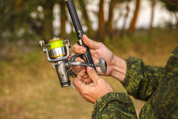 spool of fishing line on a spinning in the hands of a fisherman,