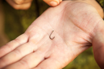 the fisherman attaches the hook to the line, close-up