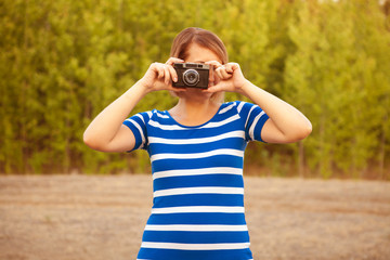 Fototapeta premium young woman in a striped dress photographed on an old film camer