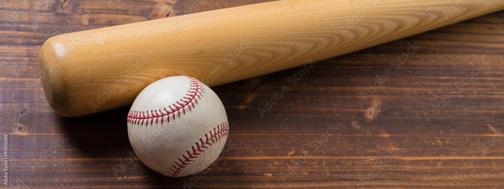 Wall mural a wooden baseball bat and ball on a wooden background