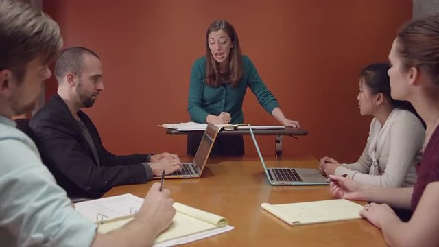 Angry business woman throws papers into the air, slow motion
