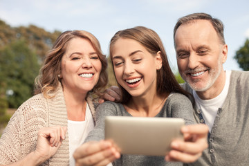 Cheerful old married couple and their daughter are resting