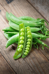 Pile of snow peas on wood background.