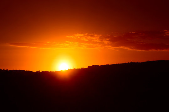 Sole che sta tramontando dietro una collina © oraziopuccio