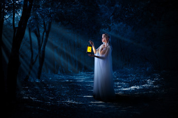 Elven girl with lantern in night forest