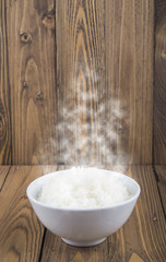 Hot Steamed Rice in a White Bowl on wooden background