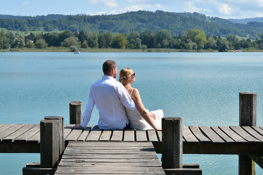 A couple on the wooden jetty at the lake. Switzerland
