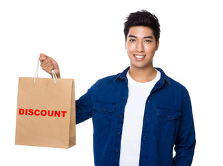 Man hold a shopping bag for showing a word discount