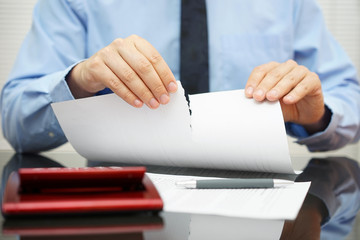 businessman tears document in office