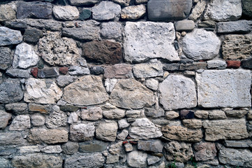 Wall built of gray stones and different sizes