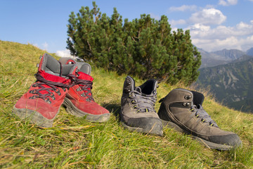 Two pairs of trekking boots on mountain slope