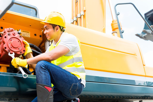 Asian Mechanic Repairing Construction Vehicle