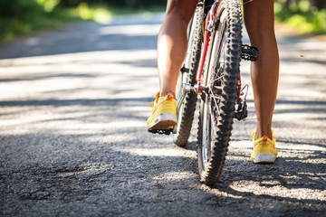 Rear view of mountain bike and woman's legs.