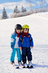 Fototapeta na wymiar Two cute little boys, brothers, skiing on a sunny day