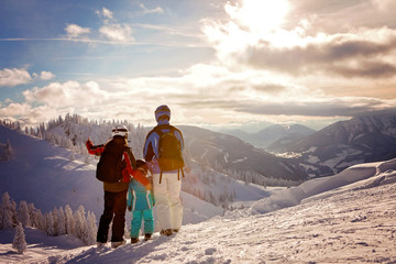 Happy family in winter clothing at the ski resort, winter time - obrazy, fototapety, plakaty