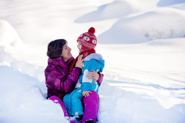 Grandmother and her grandchildren, building and playing with sno