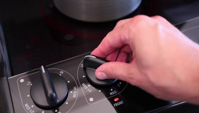Man turning on electric stove