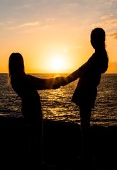 Silhouette zweier Mädchen Hand in Hand