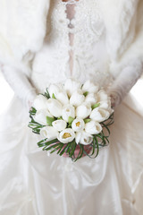 White wedding bouquet of tulips in the hands of the bride