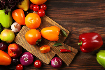 Heap of fruits and vegetables on wooden background