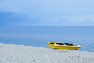Yellow boat on the sea shore.