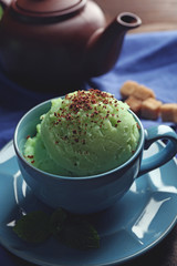 Homemade Green tea ice-cream in cup, on wooden background