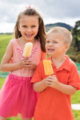 Brother and sister eating popsicles