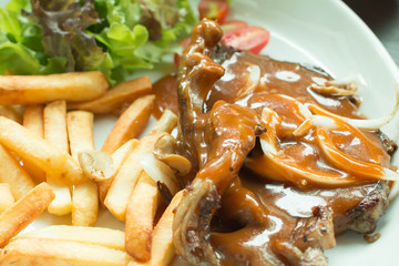 Closed up of lamb chop poured with black pepper sauce.