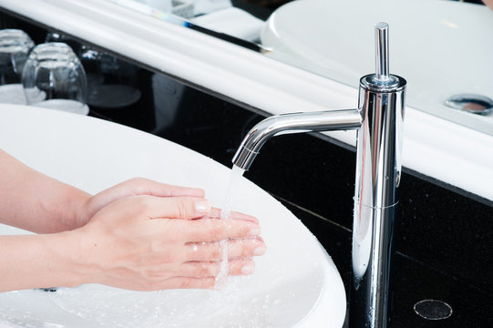 洗面台で手を洗っている,女性の手