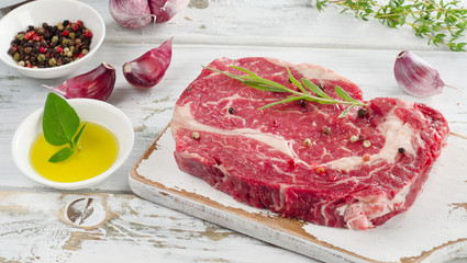 Raw ribeye steaks on cutting board.