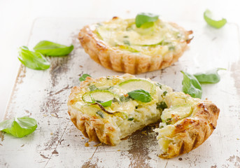Tart with cheese on a wooden background.