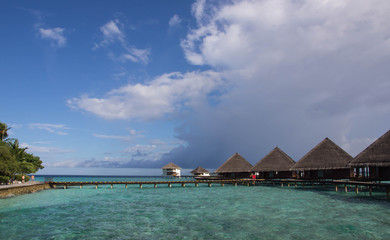 Maldivian resort on a clear day under a cloudy sky
