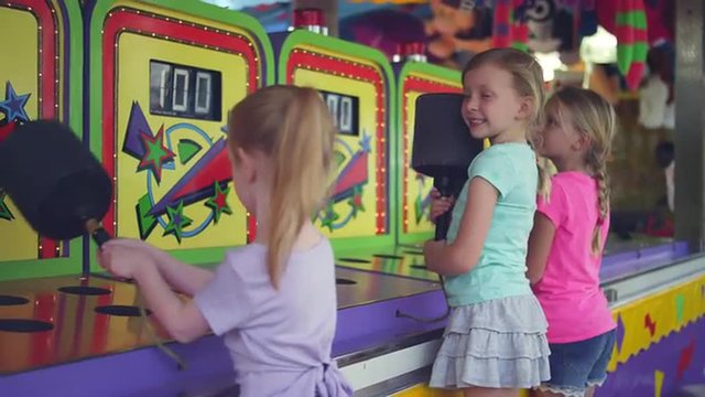 Three little girls start to play a carnival game together
