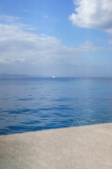 Vor dem Hafenwall erstreckt sich der blau gefärbte Atlantik, auf dem am Ende des Horizonts eine...