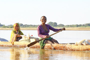 Malagasy people crossing the inlets in an outrigger canoe