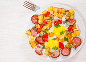 fried eggs with potato, sausage and pepper