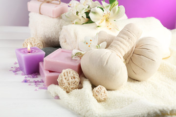Obraz na płótnie Canvas Massage bags with spa treatment and flowers on wooden table background