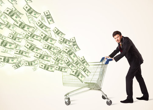 Businessman with shopping cart with dollar bills