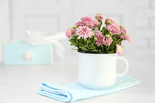Beautiful flowers in vase on table, on light background