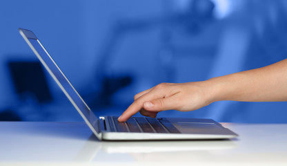Businessman pressing modern laptop computer on colorful backgrou