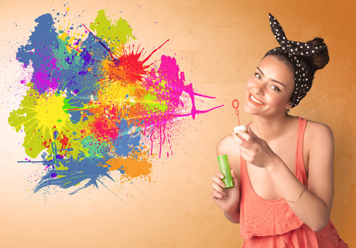 Cute girl blowing colorful splash graffiti
