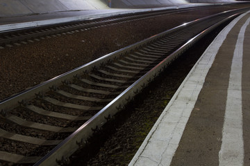 Railway station at night. Brilliant rails