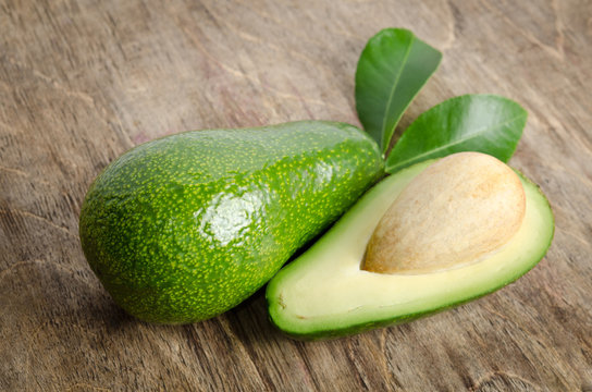 fresh avocado with a leaves  on wooden background