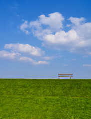 Bank auf einem Damm mit schönen Wolken hoch