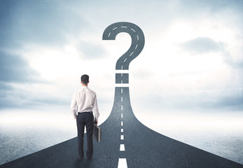 Business person lokking at road with question mark sign