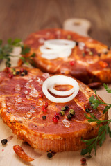 Marinated, raw pork ready for roasting on a wooden table.