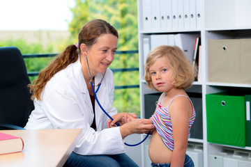 Obraz premium female pediatrician in white lab coat examined little patient