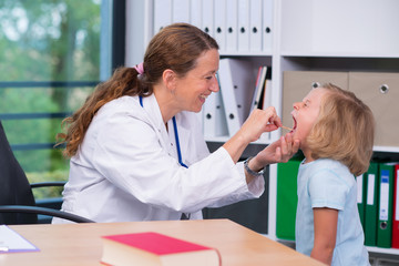 female pediatrician in white lab coat examined little patient