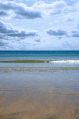 gentle blue waves lashing onto ballybunion beach